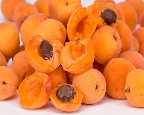 A freshly sliced ripe papaya showing its vibrant orange flesh and black seeds on a presentation board